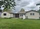 Spacious backyard showcasing a covered patio area, storage shed, and well-manicured lawn at 211 Woodlane Dr, Columbus, IN 47201