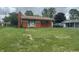 Cozy single-level home with a brick chimney, a well-maintained lawn and an attached garage at 211 Woodlane Dr, Columbus, IN 47201