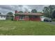 Charming single-story home with brick accents, attached garage, and lush green lawn at 211 Woodlane Dr, Columbus, IN 47201