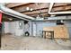 Unfinished basement area with concrete walls, hot water tank and exposed ceiling beams at 2335 Main St, Elwood, IN 46036