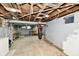 Unfinished basement area with exposed ceiling beams, concrete walls, and a punching bag at 2335 Main St, Elwood, IN 46036