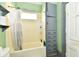 Classic bathroom with a tub/shower combo, storage cabinet and small window at 2335 Main St, Elwood, IN 46036