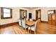 Dining area with wood floors, trim and a table with six chairs near multiple doorways at 2335 Main St, Elwood, IN 46036