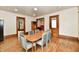 Dining area with wood floors, trim and a table with six chairs near multiple doorways at 2335 Main St, Elwood, IN 46036