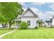 Charming home featuring a metal roof, well-kept lawn, and vibrant green foliage at 2335 Main St, Elwood, IN 46036
