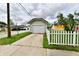 Detached garage with a white door and a driveway bordered by a picket fence at 2335 Main St, Elwood, IN 46036