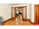 Hallway showcasing hardwood floors and original wood trim, with an open doorway at 2335 Main St, Elwood, IN 46036