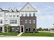 Charming townhouse with brick facade, a black front door, and well-manicured lawn and landscaping at 3279 Morab Dr, Zionsville, IN 46077