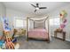 Unique bedroom with charming yellow bicycle, canopy bed, and lots of natural light at 33 N Beville Ave, Indianapolis, IN 46201