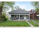 Charming single story home with a cozy front porch and well maintained lawn and landscaping at 33 N Beville Ave, Indianapolis, IN 46201