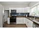 Modern kitchen with white cabinets, stainless steel appliances, and dark wood counter tops at 33 N Beville Ave, Indianapolis, IN 46201