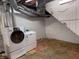 Basement laundry area features a white washer and dryer set with utility sink, painted flooring, and an open ceiling at 333 N Kenyon St, Indianapolis, IN 46219