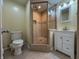 Bathroom featuring tiled shower with glass door, a toilet, and a modern sink at 333 N Kenyon St, Indianapolis, IN 46219