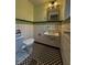 Cozy bathroom features black and white checkered floors, tiled walls, and a vintage-style fixtures at 333 N Kenyon St, Indianapolis, IN 46219