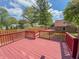 Relaxing on the spacious red deck overlooking the lush backyard with mature trees at 333 N Kenyon St, Indianapolis, IN 46219