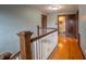 Second floor hallway with hardwood floors and traditional banister leading to multiple rooms at 333 N Kenyon St, Indianapolis, IN 46219
