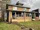 Two-story brick home featuring a quaint front porch and well-maintained lawn at 3443 Broadway St, Indianapolis, IN 46205