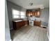 Well-lit kitchen with ample cabinet space, linoleum tile flooring and a window over the sink at 3443 Broadway St, Indianapolis, IN 46205