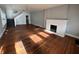 Spacious living room with hardwood floors, a decorative fireplace, and staircase access at 3443 Broadway St, Indianapolis, IN 46205