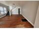 Open-concept living room featuring hardwood floors and a staircase to the upper level at 3443 Broadway St, Indianapolis, IN 46205