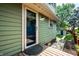 Side view of the back of the house with a glass door, light green siding and a small garden at 357 N Kenyon St, Indianapolis, IN 46219