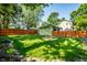 Well manicured backyard features a detached garage, wood fence, and a fire pit at 357 N Kenyon St, Indianapolis, IN 46219