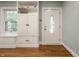 Bright entryway with hardwood floors, a white front door with decorative glass and a built-in storage at 357 N Kenyon St, Indianapolis, IN 46219