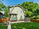Rear view of the home featuring green siding, fenced yard, and a ground level deck at 357 N Kenyon St, Indianapolis, IN 46219