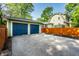 Detached two-car garage with blue doors and long driveway, and a partial view of the house at 357 N Kenyon St, Indianapolis, IN 46219