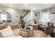 Open-concept living room with fireplace, hardwood floors, built-in shelves and staircase in view at 357 N Kenyon St, Indianapolis, IN 46219