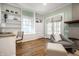 Cozy living room featuring hardwood floors, built-in shelving, chair, ottoman, and a view outdoors at 357 N Kenyon St, Indianapolis, IN 46219