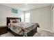 Comfortable bedroom with a dark wood bed frame and a large window for ample natural light at 3719 Lexham Ct, Danville, IN 46122