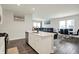 Modern kitchen with stainless steel appliances, island with bar seating, and open floor plan to living area at 3719 Lexham Ct, Danville, IN 46122