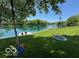 A scenic view from the grassy backyard, overlooking the tranquil lake and featuring swings at 3829 Waycross Dr, Columbus, IN 47203