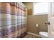 Neutral-toned bathroom featuring a shower and toilet with a window providing natural light at 3829 Waycross Dr, Columbus, IN 47203