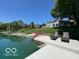 A view of the lake with a private dock, lounge chairs and manicured lawns on a sunny day at 3829 Waycross Dr, Columbus, IN 47203