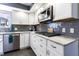 Well-lit kitchen featuring white cabinets, grey subway tile backsplash, stainless steel appliances, and modern countertops at 3829 Waycross Dr, Columbus, IN 47203