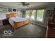 Relaxing bedroom featuring a wooden bed frame, large window with scenic views and hardwood floors at 3829 Waycross Dr, Columbus, IN 47203