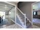 Entryway view of the staircase with decorative patterned tile flooring and open access to the kitchen and living areas at 3829 Waycross Dr, Columbus, IN 47203