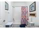 Bright bathroom featuring a shower with a floral curtain, white fixtures, and decorative wall art at 410 Angelina Way, Avon, IN 46123