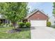 Charming brick home featuring a two-car garage and a well-manicured lawn at 410 Angelina Way, Avon, IN 46123