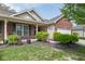 Charming brick home with a manicured lawn, lush landscaping, and a welcoming front porch at 410 Angelina Way, Avon, IN 46123
