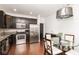Modern kitchen featuring stainless steel appliances, dark cabinetry, and a dining area at 410 Angelina Way, Avon, IN 46123