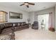 Spacious living room featuring a leather sectional sofa, ceiling fan, and a large mirror at 410 Angelina Way, Avon, IN 46123