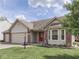 Charming home featuring a three-car garage, brick accents, a front lawn and a vibrant red front door at 4675 Walker St, Greenwood, IN 46143