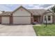 Charming home featuring a three-car garage, brick accents, and a vibrant red front door at 4675 Walker St, Greenwood, IN 46143