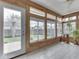 Light-filled sunroom with wood paneling, tile flooring, and large windows showcasing the backyard at 4675 Walker St, Greenwood, IN 46143