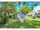 A charming backyard has a fire pit, a dining table set, and lots of trees at 5015 Carrollton Ave, Indianapolis, IN 46205