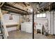 Unfinished basement with laundry area, utility sink, exposed ceiling, and concrete floor at 5015 Carrollton Ave, Indianapolis, IN 46205