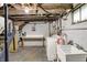 Unfinished basement with laundry area, utility sink, exposed ceiling, and concrete floor at 5015 Carrollton Ave, Indianapolis, IN 46205